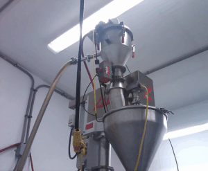 VAC-U-MAX custom pneumatic conveying system above filling machine at Nutriom plant.
