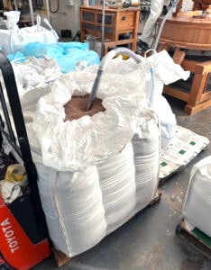 Locally grown whole grains being vacuumed from bulk bags