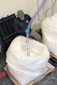 Man easily conveying from a 2000-pound bulk bag of sugar