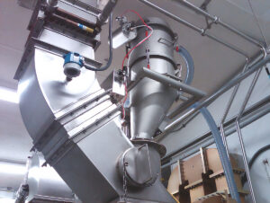 Vacuum conveyor shown as part of a two-stage system: one unit fluidizes and transfers powder to the mixer, while a second unit conveys finished material from the mixer to the next process step.
